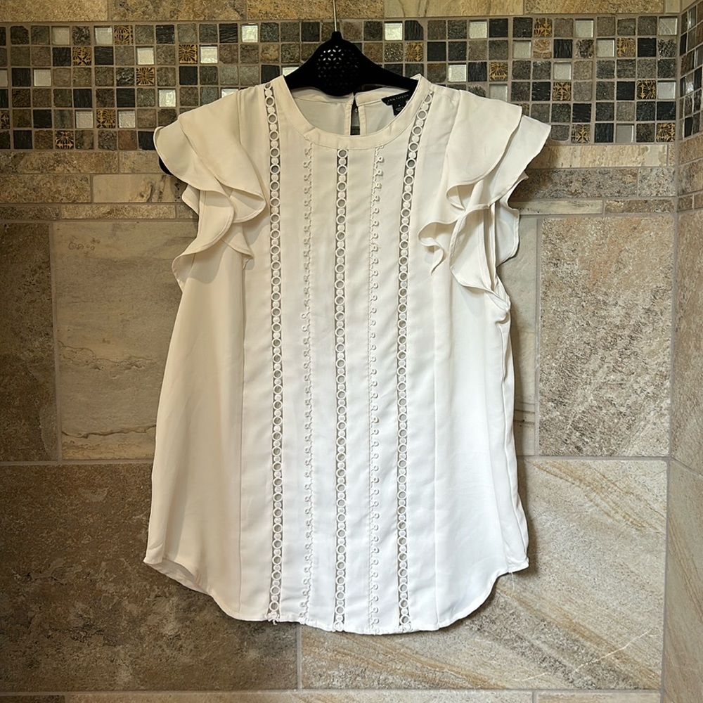 White with short ruffle sleeve and see through detail down the front.